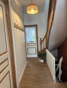 um corredor com uma escada com uma porta e uma janela em Ulyssee Seh’Loué em Saint-Brieuc