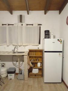 uma cozinha com um frigorífico branco e um lavatório em La Gitana - Casa en La Paloma em La Paloma