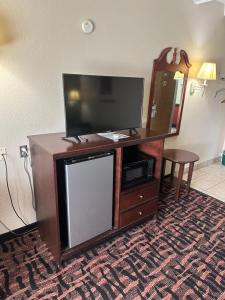 a flat screen tv sitting on top of a wooden entertainment center at Rodeway Inn in Zanesville