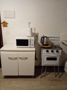 y cocina con microondas y fogones. en La Gitana - Casa en La Paloma, en La Paloma