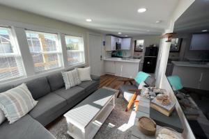 ein Wohnzimmer mit einem grauen Sofa und einer Küche in der Unterkunft The Hideaway in Beaufort