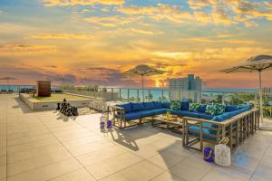um pátio com sofás azuis e guarda-sóis no telhado em Costa Hollywood Design em Hollywood