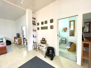 Pedro Vicente MaldonadoにあるDepartamento 2 habitaciones- Piscina, Botánico, BBQ, Terraza - THE GARDEN HOUSEのリビングルーム(鏡、椅子付)