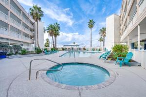 uma banheira de hidromassagem num pátio com cadeiras e palmeiras em Corpus Christi Condo Pool and Access to North Beach em Corpus Christi