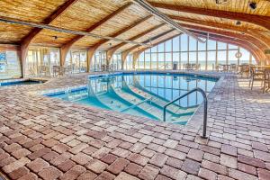 uma piscina com mesas e cadeiras num edifício em Sands Ocean Club 833 em Myrtle Beach