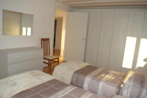 a bedroom with two beds and a dresser and a chair at Locazione turistica Aquila in Verona