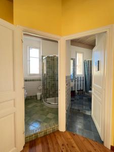a bathroom with a walk in shower and yellow walls at Maison RE- splendido appartamento centro Mentone in Menton