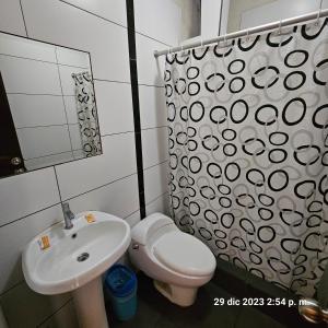 y baño con lavabo, aseo y espejo. en Hostal La Cascada en Lima