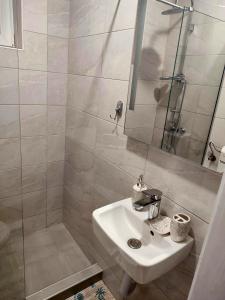 y baño blanco con lavabo y ducha. en Holiday home Ravna Planina en Pale
