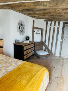 um quarto com uma cama, uma cómoda e um espelho em Maison en Colombage em Tilly