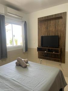 - une chambre avec un lit et une télévision à écran plat dans l'établissement Pousada Recanto do Norte, à Florianópolis