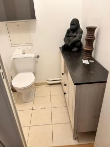 a bathroom with a statue of a gorilla sitting on a counter at cosy appartement Disneyland Paris val d'Europe la vallée Village parking inclus 650m de la gare RER in Montévrain
