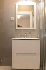 a bathroom with a white sink and a mirror at Apartment Dora 3,beach apartment in Tivat