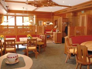 un restaurant avec des murs en bois, des tables et des chaises dans l'établissement Pension Cafe Fritz, à Lech am Arlberg
