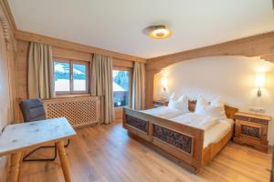 een slaapkamer met een bed, een bureau en een tafel bij Haus Forelle in Inneralpbach