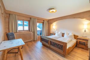 una camera con letto, scrivania e tavolo di Haus Forelle a Inneralpbach