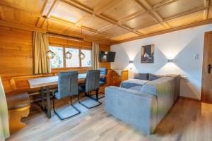 a dining room with a table and chairs and a couch at Haus Forelle in Inneralpbach