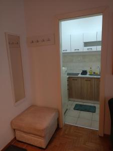 - une cuisine avec une grande fenêtre et un tabouret dans la chambre dans l'établissement Clockwork orange apartment, à Vračar (historical)