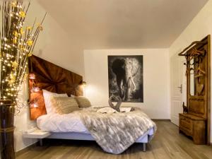 a bedroom with a bed and a picture of an elephant at DELUX L'EVASION in Saverne