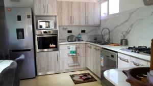 a kitchen with a stainless steel refrigerator and a sink at 3 bedrooms villa with shared pool furnished terrace and wifi at Pointe aux Piments in Pointe aux Piments
