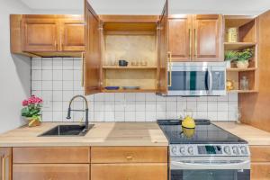 a kitchen with wooden cabinets and a stove top oven at 1 BR Patio Paradise in Central City in Philadelphia