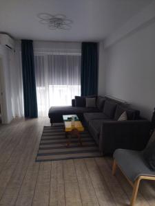 a living room with a couch and a table at Astoria Apartament vedere la mare in Mamaia Sat/Năvodari