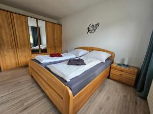 ein Schlafzimmer mit einem großen Bett mit einem Holzrahmen in der Unterkunft Ferienwohnung Hoch im Harz, Altenau in Altenau