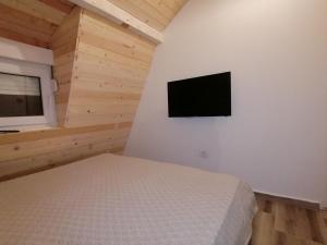 a bedroom with a bed and a television on a wall at A Bre Da Bre Family Club in Niš