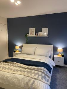 1 dormitorio con 1 cama grande y pared azul en Modern 2 BDR Flat in Nottingham City Centre with FREE Parking, en Nottingham