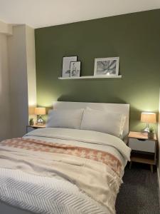 um quarto com uma cama grande e uma parede verde em Modern 2 BDR Flat in Nottingham City Centre with FREE Parking em Nottingham