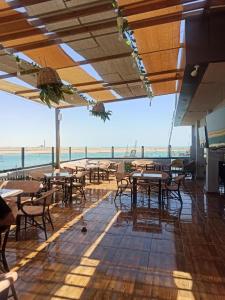 een restaurant met tafels en stoelen en uitzicht op de oceaan bij Salvatore Room With Breakfast-Sea View in Suez
