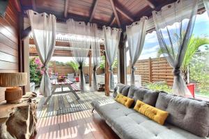 a living room with a couch and curtains at Residence De La Cousiniere in Vieux-Habitants