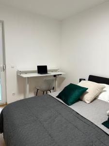 a bedroom with a bed and a desk with a laptop at Harmony Living - 10 min to Graz in Lassnitzhöhe