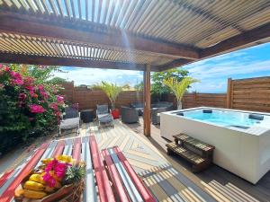 a deck with a swimming pool and a table with a bench at Residence De La Cousiniere in Vieux-Habitants