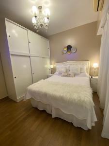 a bedroom with a large white bed and a chandelier at Moderno en Corazón Palermo Soho in Buenos Aires