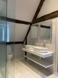 a bathroom with two sinks and a toilet at High street, Bruton in Bruton +32 photos