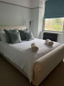 a large white bed with two towels on top of it at High street, Bruton in Bruton