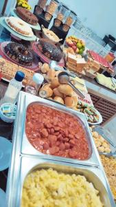 uma mesa com muitos tipos diferentes de alimentos sobre ele em Pousada Helena em Penha