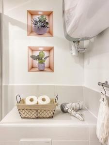 a bathroom with a shelf with towels and a plant at DELUX L'EVASION in Saverne