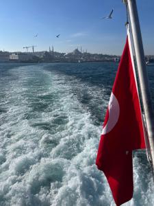 un barco con bandera roja en el agua en Lux sea view willas, en Estambul