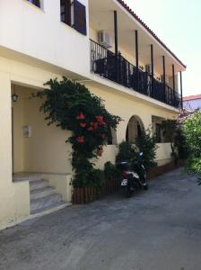 a motorcycle parked in front of a building with flowers at Eleni's House Skiathos in Skiathos