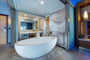 a large white tub in a bathroom with a sink at Shade Hotel Manhattan Beach in Manhattan Beach