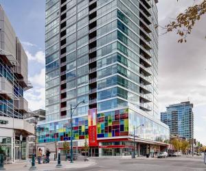 a tall glass building with colorful windows in a city at ColoursNest - Downtown apt spectacular view and location in Calgary