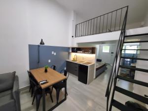 uma cozinha e sala de jantar com uma mesa e um loft em LOFT MUNDI - Conforto no Centro com Ar Condicionado em Águas de Lindoia