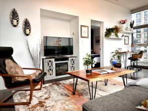 a living room with a tv and a table at ColoursNest - Downtown apt spectacular view and location in Calgary