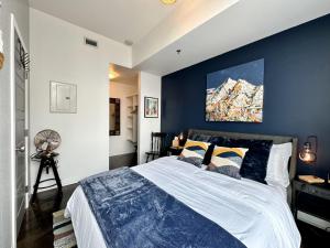 a bedroom with a large bed with a blue wall at ColoursNest - Downtown apt spectacular view and location in Calgary