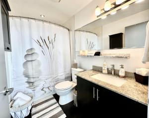 a bathroom with a toilet and a shower and a sink at ColoursNest - Downtown apt spectacular view and location in Calgary +24 photos