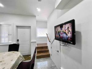 ein Wohnzimmer mit einem Flachbild-TV an der Wand in der Unterkunft Vancouver’s Homey Laneway House in Vancouver