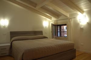 a bedroom with a bed and two lights on the wall at Locazione Turistica Aquila in Verona