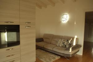 een woonkamer met een bank en een magnetron bij Locazione Turistica Aquila in Verona